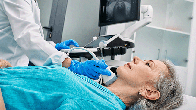 Frau wird per Ultraschall an der Halsvene untersucht